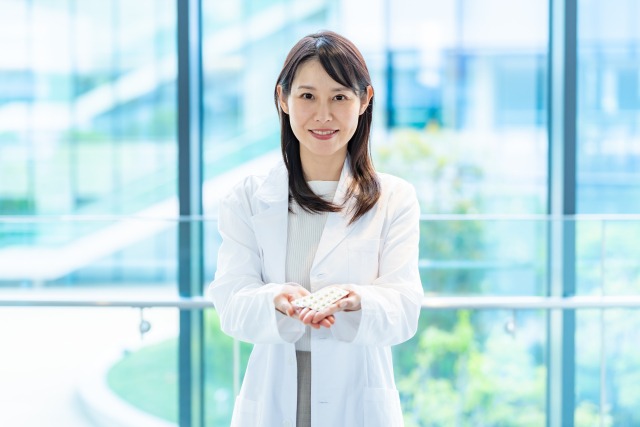 薬を差し出す女性薬剤師
