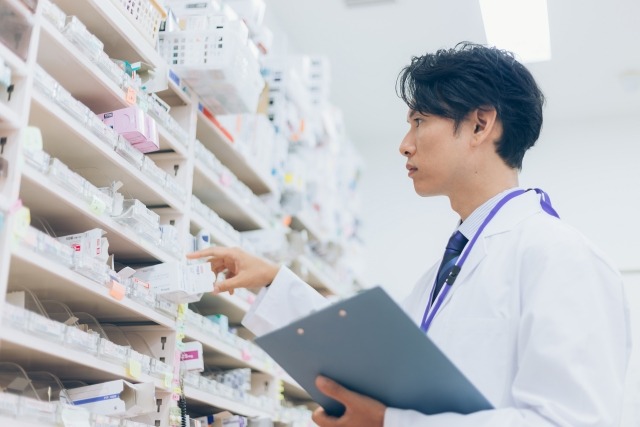 薬局で薬を確認する男性薬剤師